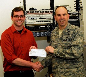 In February, Bryan Rudes (l), an engineering instructor at Nuames High School in Layton, Utah, receives the chapter's $1,000 Science Teaching Tools grant from Col. Bailey.